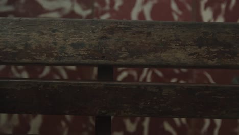 hands with muscle wrinkles interlocked on an old wooden chair