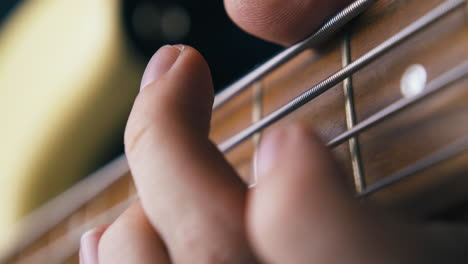 artist fingers play bass guitar with pitch shift technique