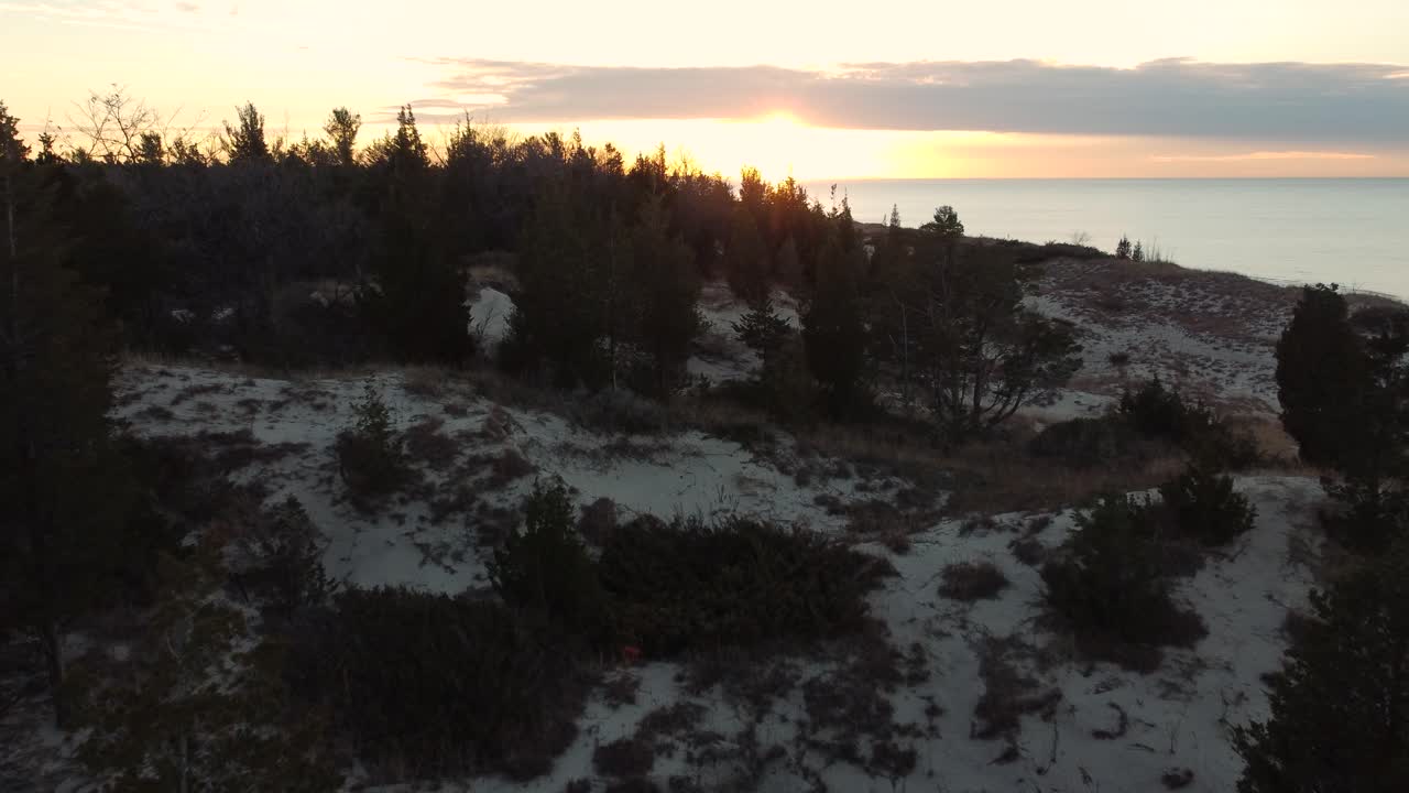 disparo aéreo hacia el atardecer mientras los terrenos de abajo están cubiertos de nieve