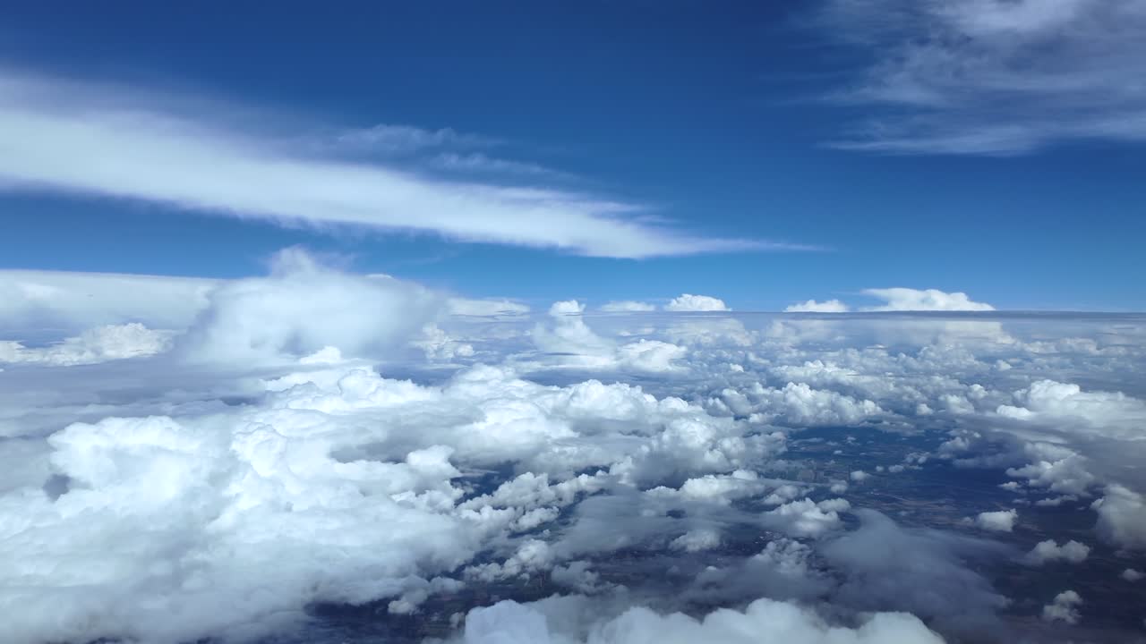 An immersive cockpit view through the pilot’s eyes while flying peacefully in a blue sky, over cottony storm clouds. Ultra-realistic 4K footage
