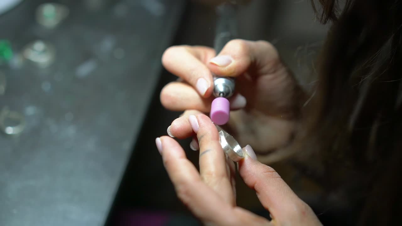 una mujer pulindo un anillo de plata.