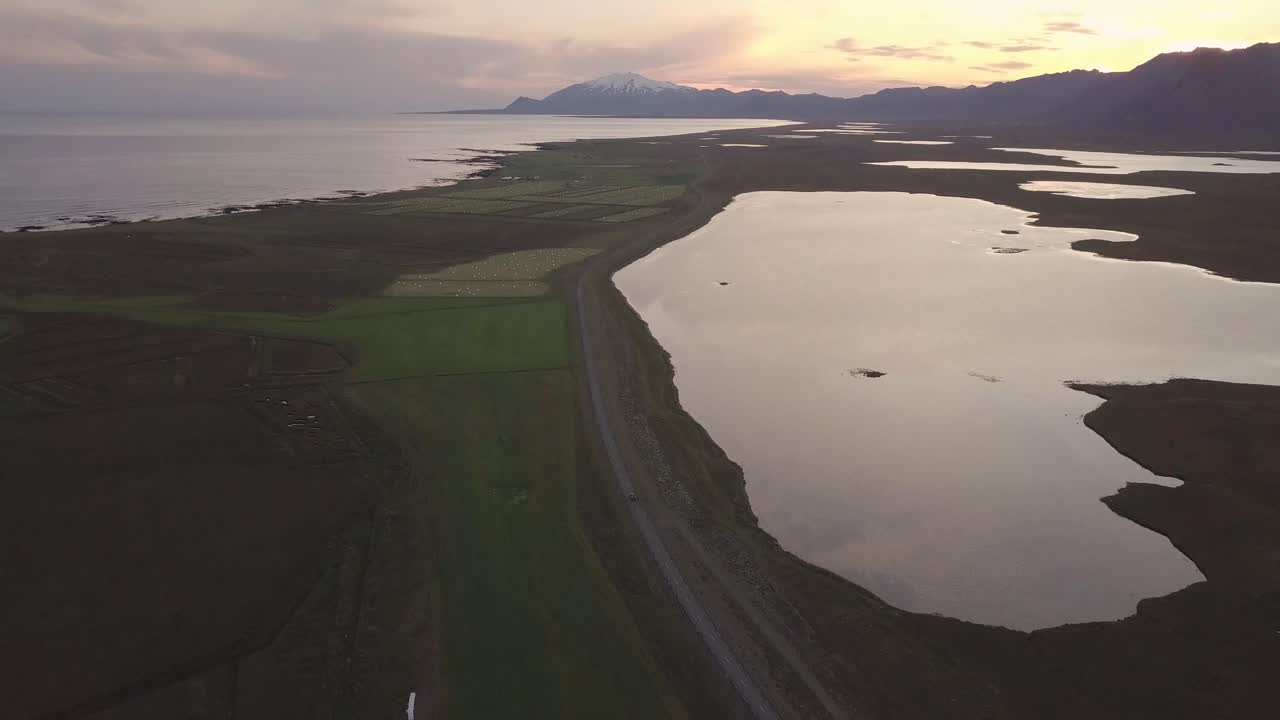 아이슬란드 스내펠스니스 반도에서 흐린 여름 일몰 동안 호수, 바다, 산, 스내펠스 화산의 항공 영상