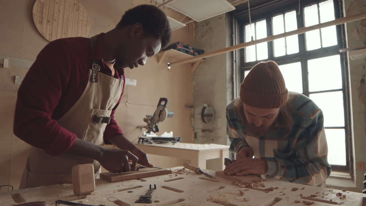 Two Diverse Joiners Carving Wooden Boards
