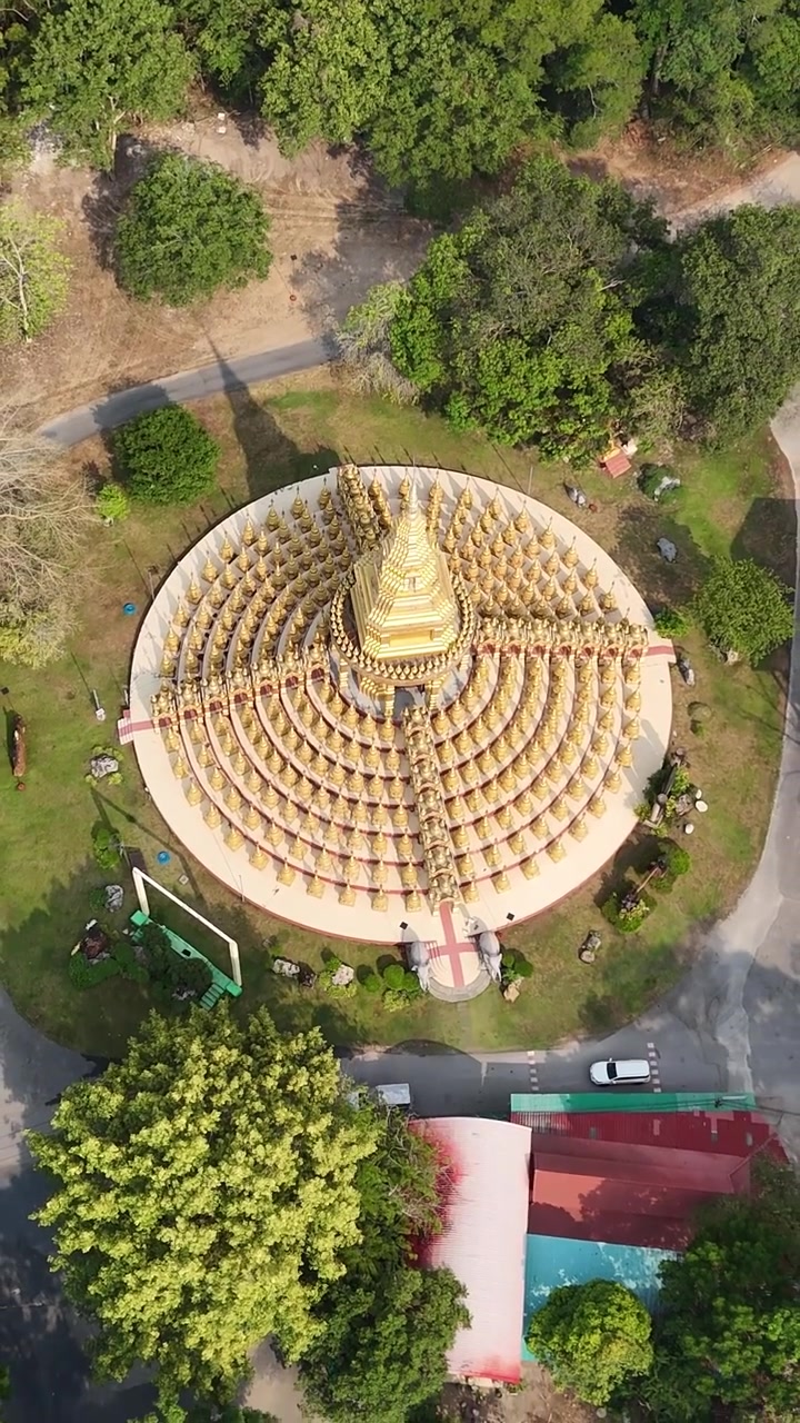 Inclinazione aerea verticale verso il basso sopra la Pagoda d'oro Chedi 500 Yot a Wat Pa Sawang Bun, che rivela guglie buddiste simmetriche a Saraburi, Thailandia