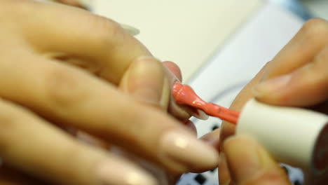 closeup shot of a woman in a nail salon receiving manicure by beautician