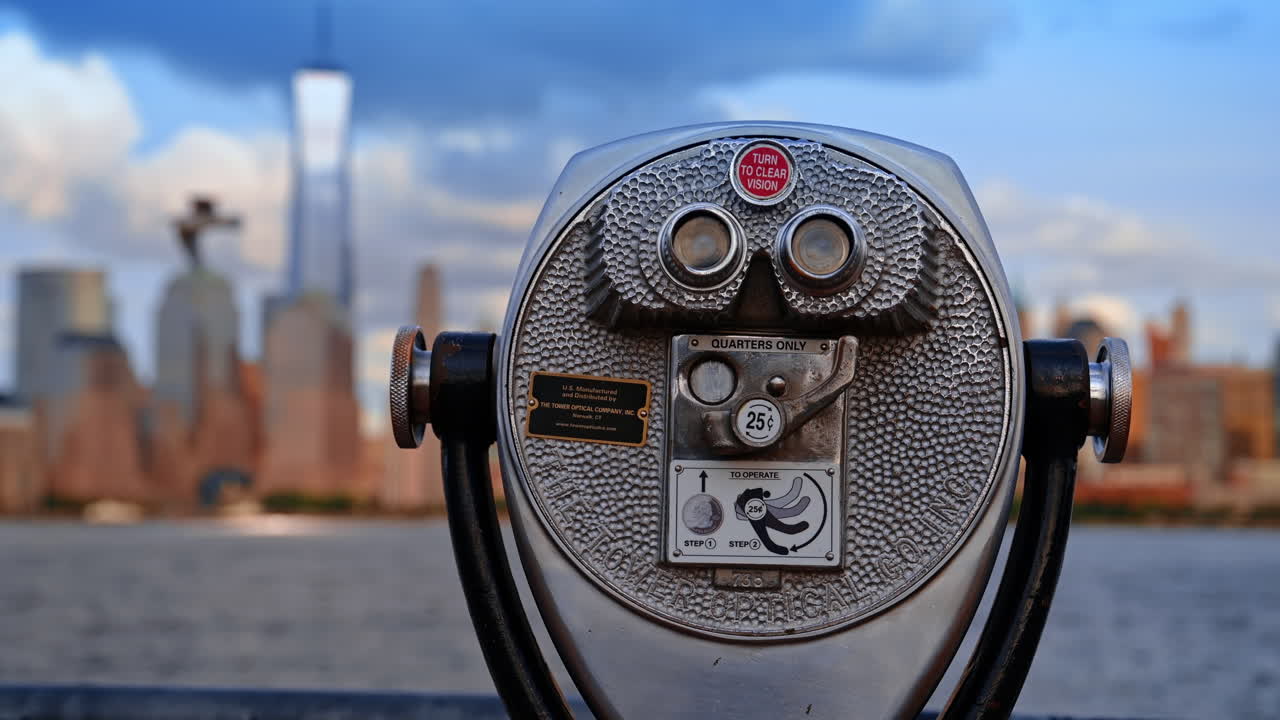 Jersey City, USA, 11 luglio 2025: Binocolo che inquadra Manhattan da Jersey City. Primo piano di un binocolo rivolto verso lo skyline di New York City dal lungomare di Jersey City