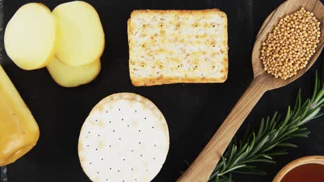 sliced cheese with crispy biscuits, seeds, rosemary herb and sauce