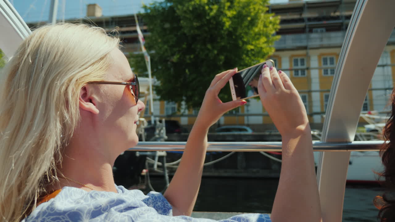 A Woman Takes Pictures Of Herself Against The Background Of Copenhagen's City Line Sails On A Sights