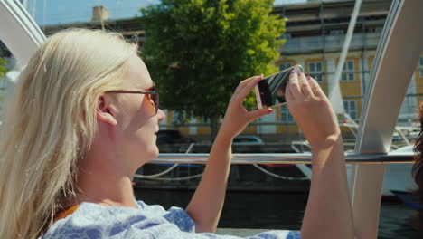 una mujer toma fotografías de sí misma en el contexto de las velas de la línea de la ciudad de copenhague en un lugar de interés