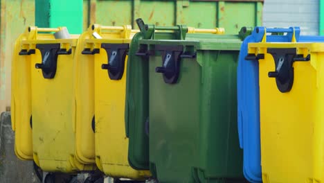 colorful plastic garbage bins stacked in a row at the landfill, environmental pollution, medium shot