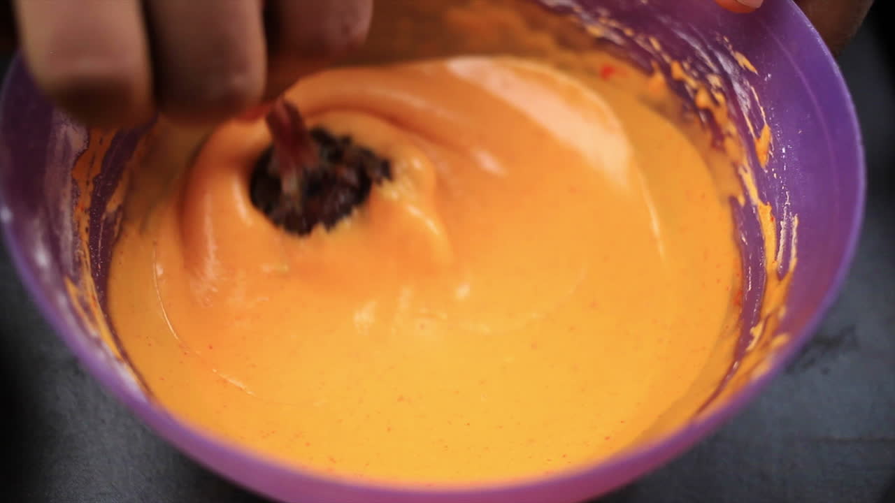 el chef cubrió el trozo de piruleta de pollo con una masa espesa bien mezclada para freírlo y preparar una comida picante y picante no vegetariana