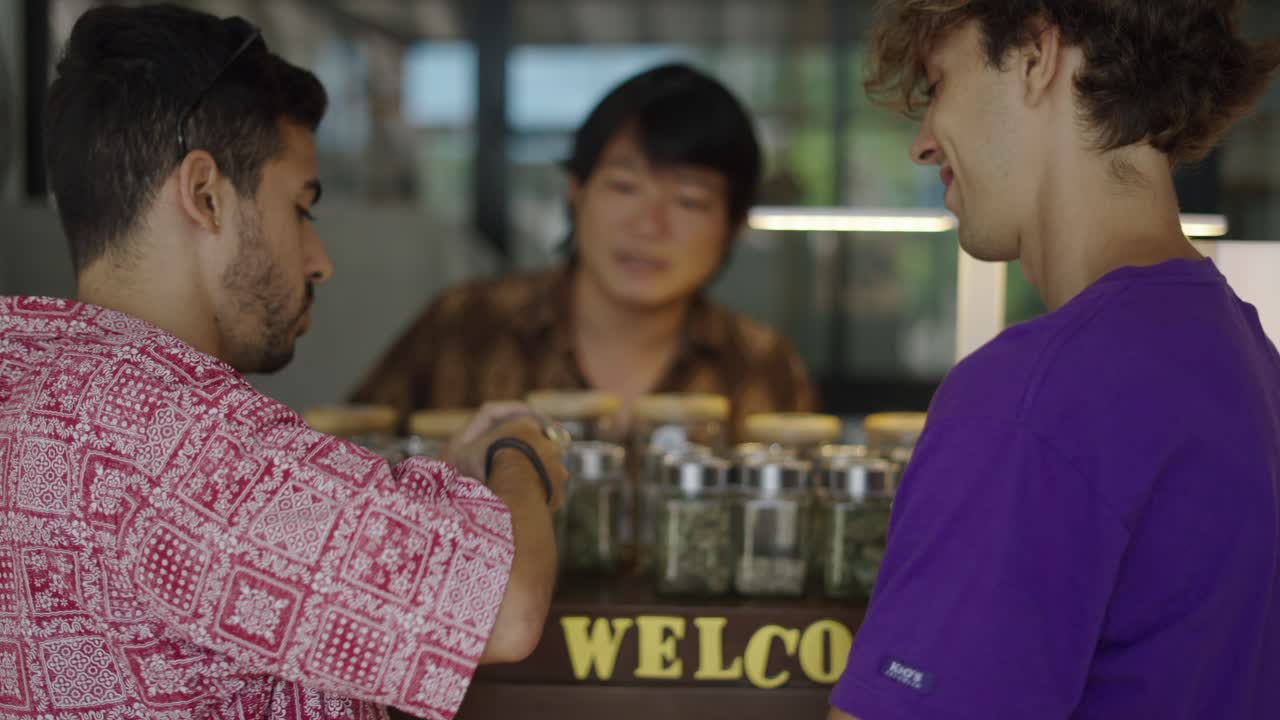 Men examining cannabis buds at a dispensary
