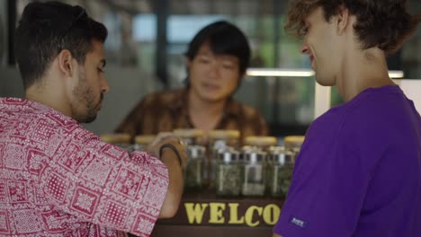 men examining cannabis buds at a dispensary