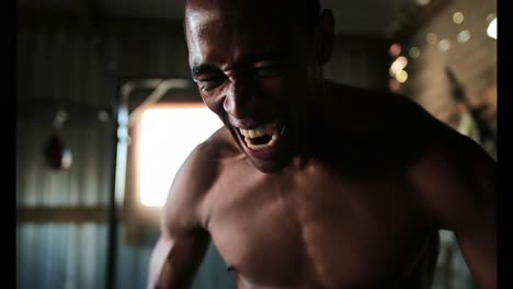 African-American-aggressive-male-boxer-standing-in-fitness-studio-4k