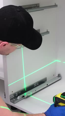 a man collects kitchen furniture repair of the kitchen using a construction laser
