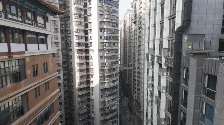 Ripresa al rallentatore dall'alto del Kuixinglou che mostra edifici residenziali multipiano densamente popolati con balconi e bucato, Chongqing, Cina, in una giornata nuvolosa