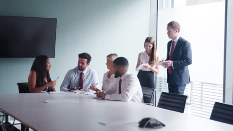 grupo que colabora en una tarea en el día de evaluación de la contratación de graduados mientras es observado por el equipo de contratación