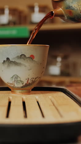 pouring tea into a decorative tea cup