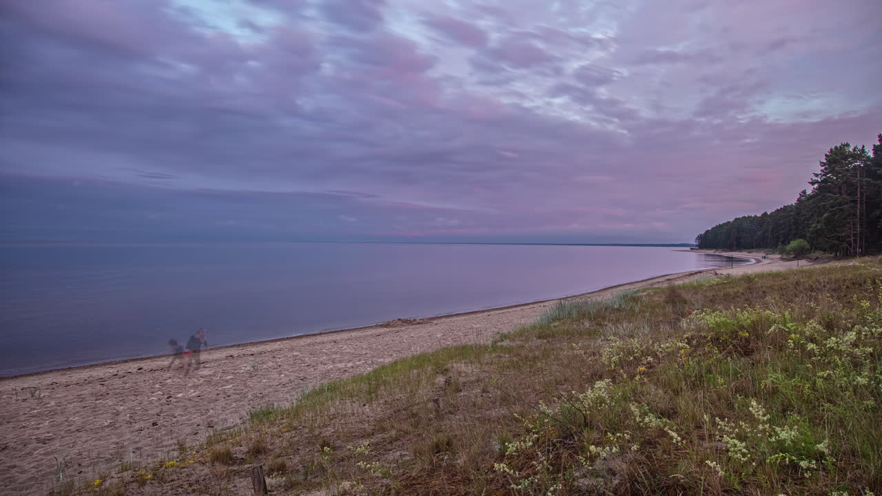 lapso de tiempo tranquilo en la playa con nubes rosadas y violetas