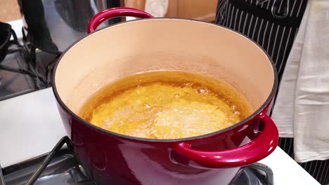 carefully sliding raw dough into hot oil to make indian bhatura bread - chana masala series