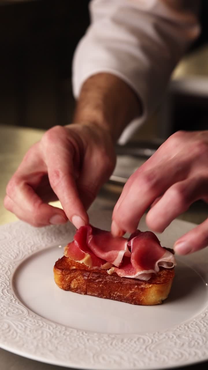 Chef's Hands Placing Prosciutto on Toasted Bread