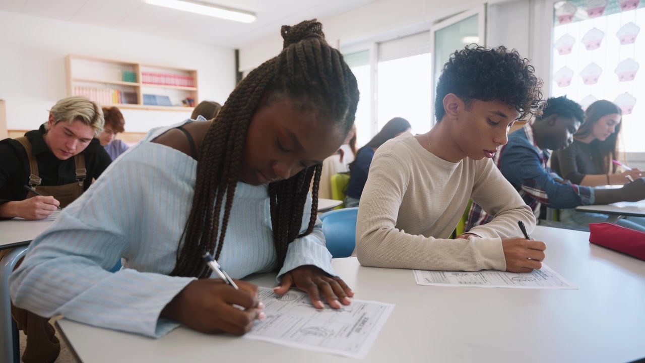 Diverse Students Taking a Written Exam in a Classroom