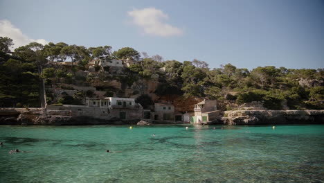 people swim in a turquoise lagoon on the beautiful island of mallorca