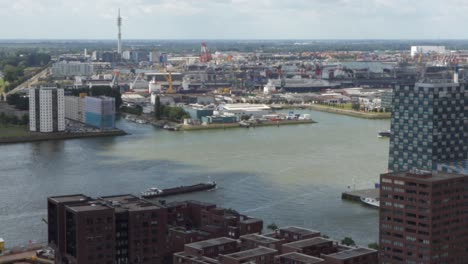 cargo boats sailing on nieuwe maas in the city of rotterdam, netherlands