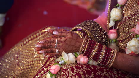 henna painted hands of a beautifully dressed indian bride praying during wedding ceremony. hindu arranged marriage in india, asia