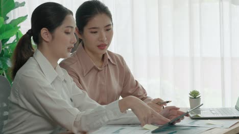 two young enthusiastic businesswoman working together in the office workspace.