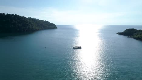 Wide-shot-of-fishing-boat-in-the-sea-with-the-sun-reflecting-on-water
