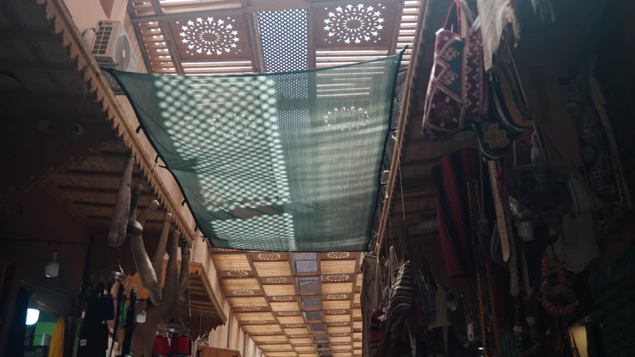 Wooden roof with brass lanterns and fabrics inside Marrakech Medina souk