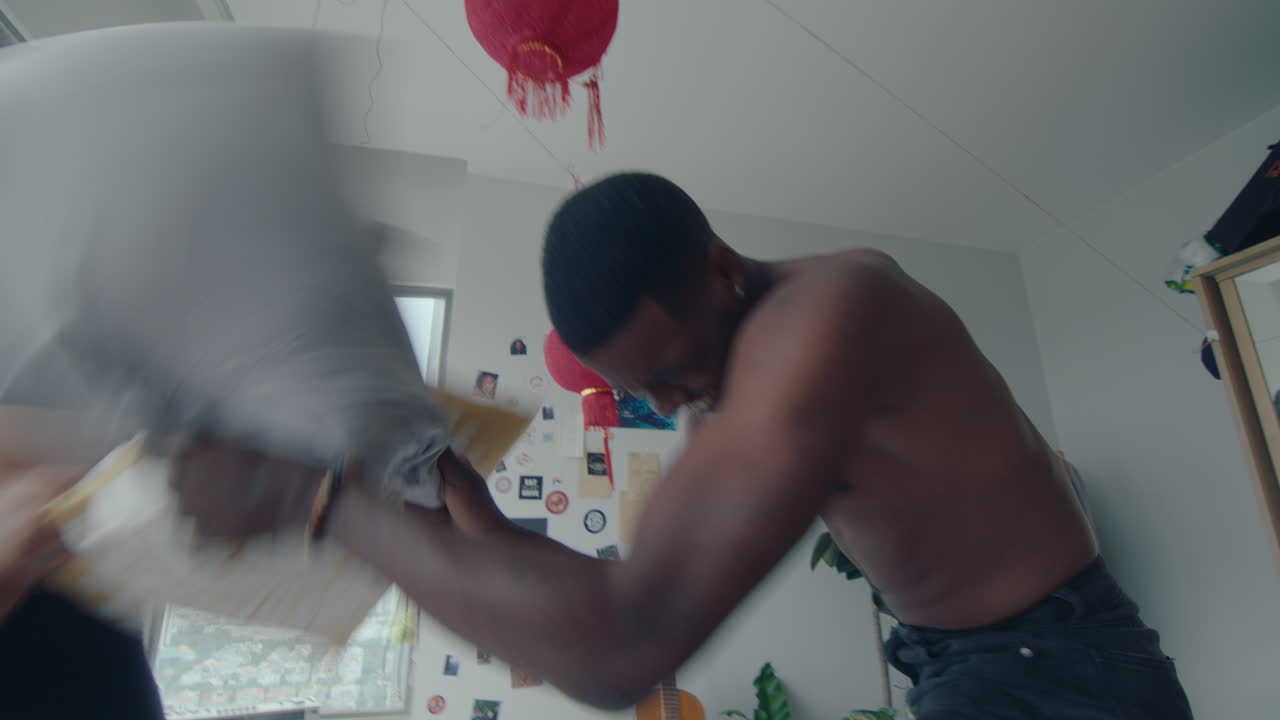 Young Lovers Having Fun and Playing Pillow Fight in Bedroom