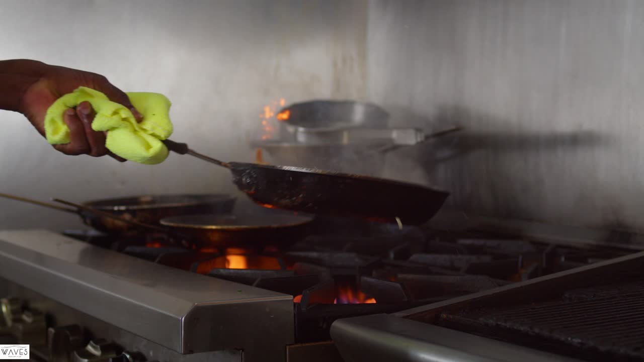 camarones junbo fritos en la estufa con el chef sosteniendo y volteando la sartén en la cocina