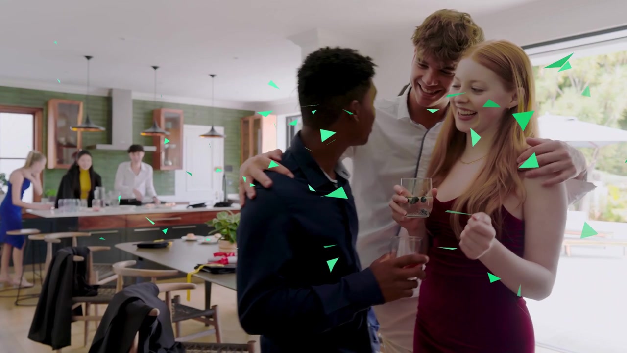 Man and woman chatting at event, tall man walking joining to greet green confetti overlaying