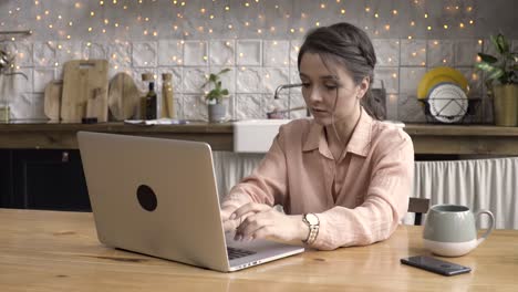 woman working from home on laptop in a kitchen