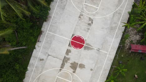 an empty basketball court in bohol, philippines, surrounded by greenery, aerial view