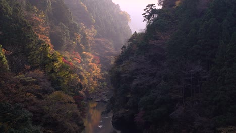 Valle-Inundado-Por-La-Luz-Del-Sol-Con-Follaje-De-Otoño-Detrás-De-La-Colina-Recortada