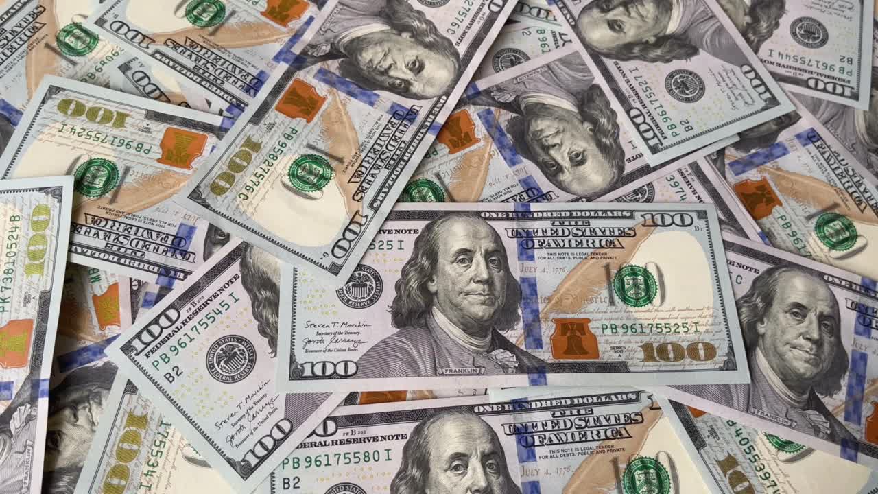 Banconote da cento dollari che cadono in primo piano. Sfondo video con denaro.