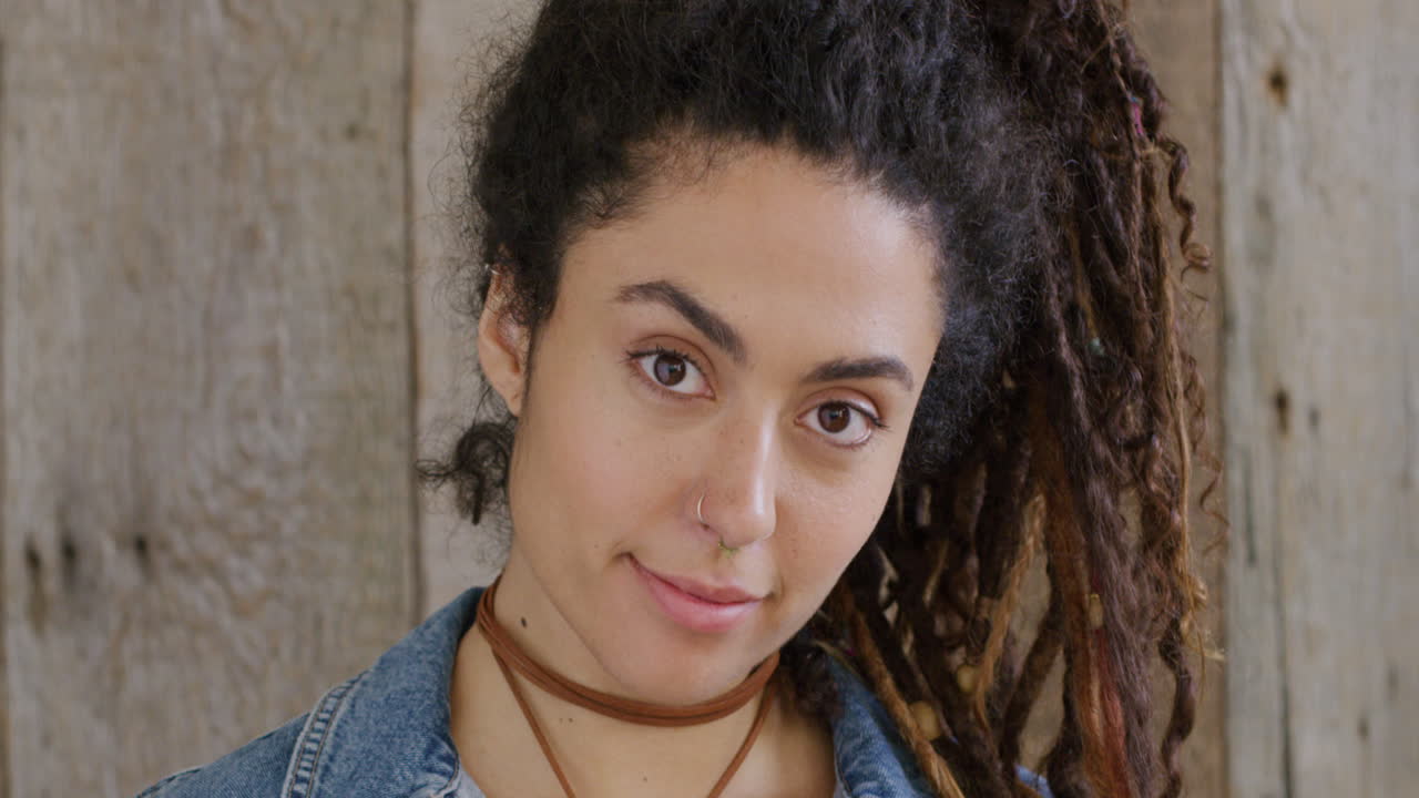 retrato de mujer de raza mixta con dredlocks sonriendo