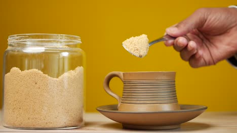 slow motion of pouring white sugar in a coffee cup , top view ,