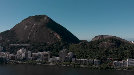 fast aerial pan around the city lake lagoa rodrigo de freitas in rio de janeiro showing the mountainous surrounding with the corcovado and two brothers mountains as well as the neighbourhood ipanema