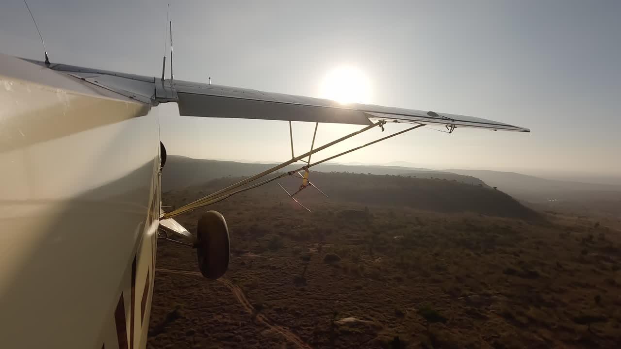 Pequeno avião em vista lateral sobre arbustos e colinas