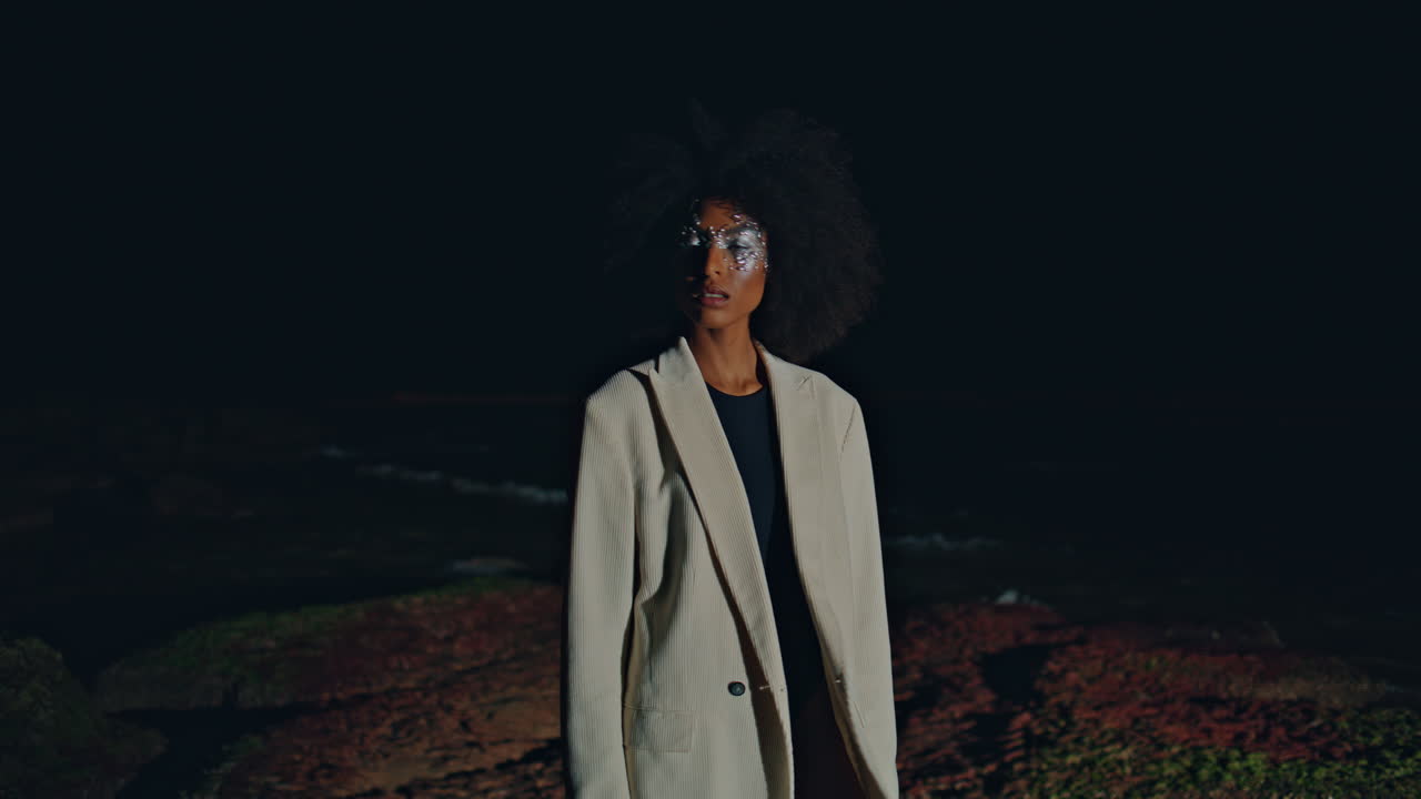 Vogue girl standing beach in dark background. Fashion model looking distance