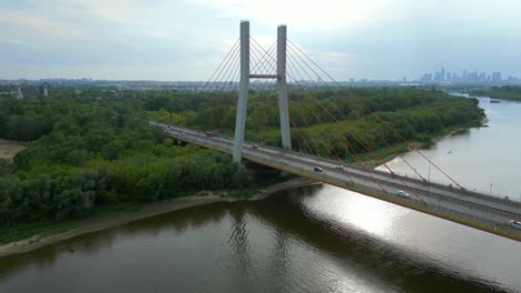 Aerial-reveal,-panoramic,-Siekierkowski-bridge,-city-skyline,-traffic