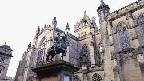 Pan-down-from-Charles-II-in-Parliament-Square-to-the-back-of-St-Giles'-Cathedral-on-a-cloudy-day,-Edinburgh,-Lothian,-UK