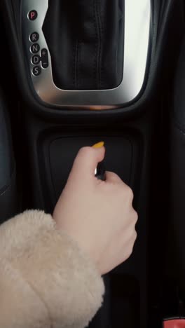 woman's hand operating car gear shift and controls