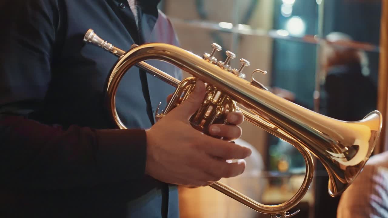 Musicista che tiene in mano un flicorno in ottone dorato