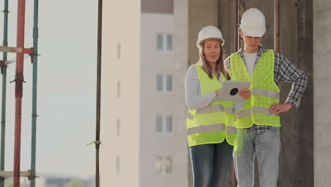 construction worker and engineer talking at construction site site. workers in helmets at building area. portrait of construction engineers working on building site. concept of modern construction