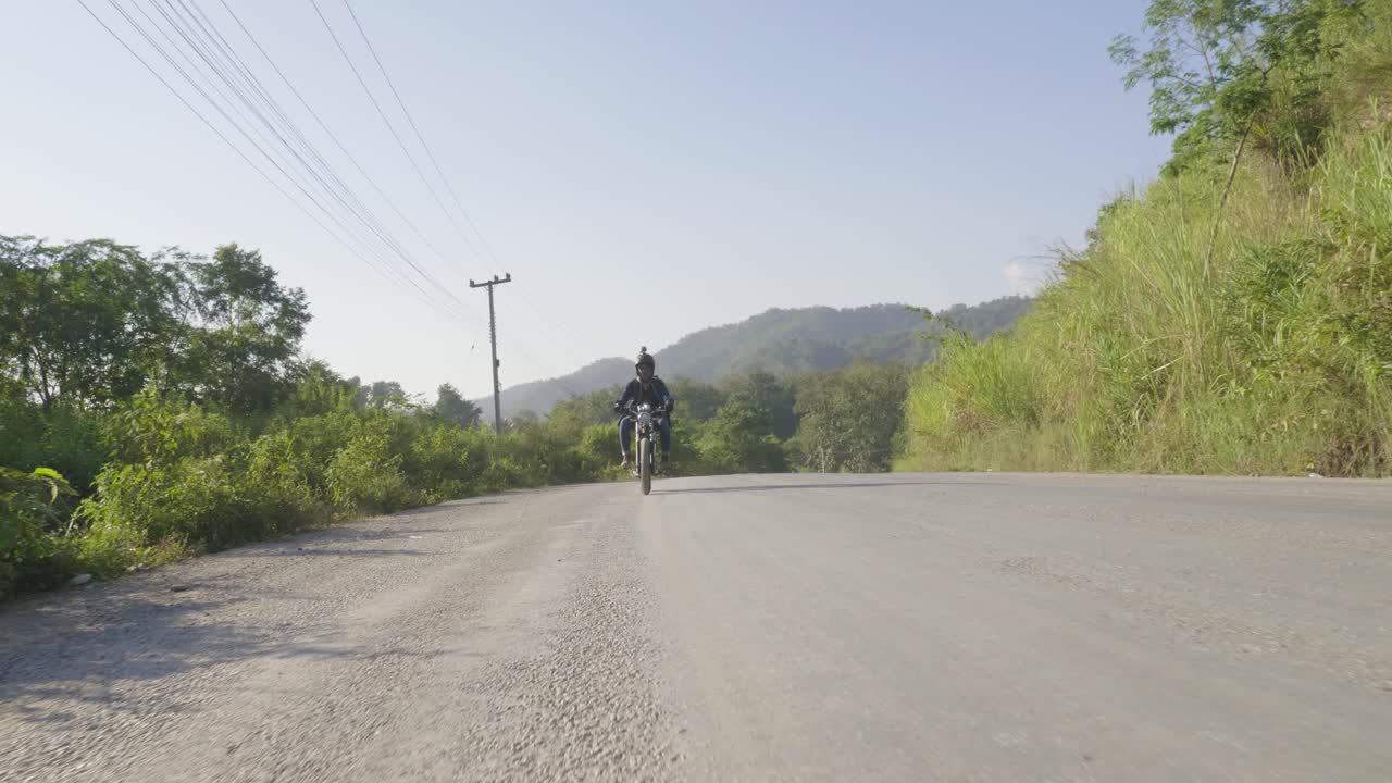 Motociclista su una strada di campagna